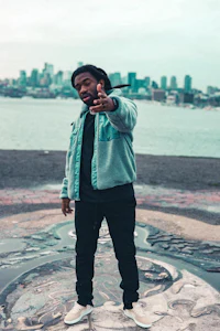 a man with dreadlocks standing in front of a city