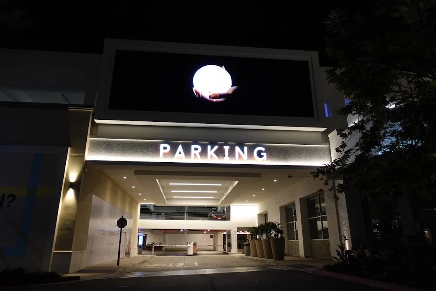 the entrance to a parking lot at night