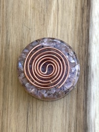 a copper spiral pendant on a wooden table