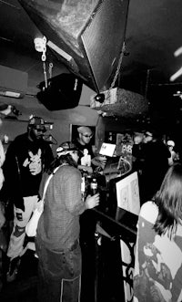 a black and white photo of a group of people in a bar
