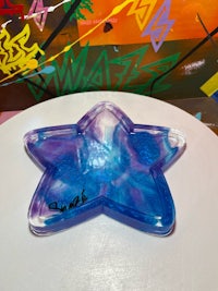 a blue and purple star shaped ashtray on a table