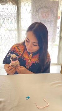 a woman is sitting at a table with a stuffed animal