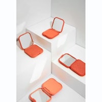 a set of orange compacts on top of a white surface