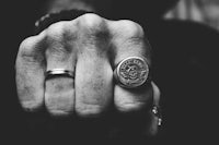 a black and white photo of a man wearing a ring