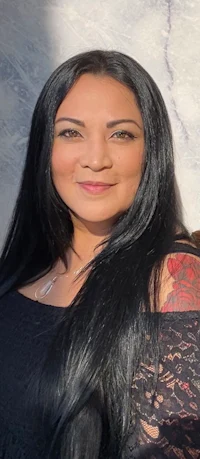 a woman with long black hair posing for a photo