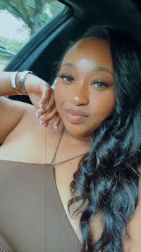 a woman in a brown dress sitting in a car