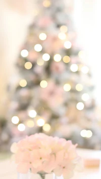 a christmas tree with pink flowers in front of it