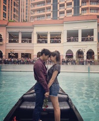 a couple in a gondola kissing in front of a building
