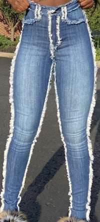 a woman wearing a pair of jeans with frayed hems
