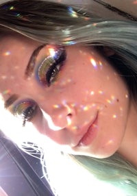 a girl with green hair and rainbow eyeshadow