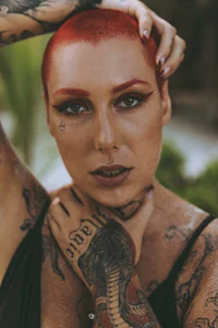 a woman with red hair and tattoos posing