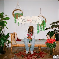 a man sitting on a bench next to flowers