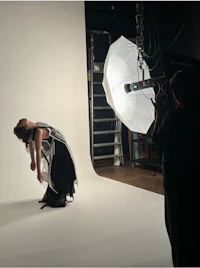 a woman is posing in front of a white background