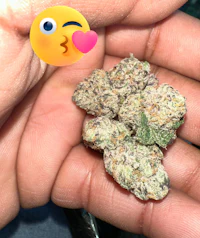 a person holding a purple marijuana flower with an emoji on it