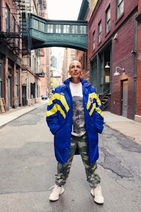 a man in a blue jacket standing on a street