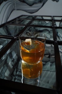 a glass of whiskey sitting on top of a glass table