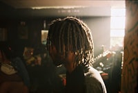 a man with dreadlocks in front of a group of people