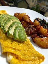 an omelet and potatoes on a white plate