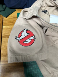 a ghostbusters jacket with an embroidered logo on it
