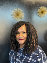 a woman in a plaid shirt standing in front of a wall