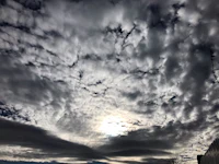 the sun shines through a cloudy sky