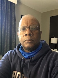 a man wearing glasses and a hoodie taking a selfie