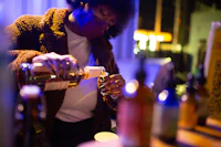 a woman is pouring a drink into a bottle