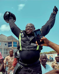 a man in a police uniform is holding up a cell phone