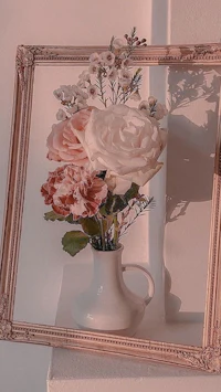a vase of flowers in a frame on a shelf