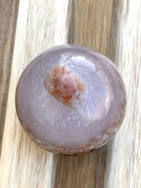 a piece of pink quartz sitting on top of a wooden table