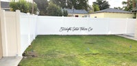 a backyard with a white fence and grass
