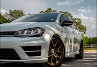 a white volkswagen golf r parked on a road
