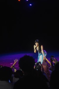 a woman performs on stage in front of a crowd