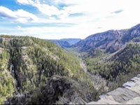 a view of a canyon with trees in the background