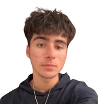 a young man wearing a blue hoodie and a necklace