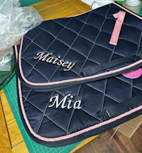 two horse saddle pads with the name masey and mia on them