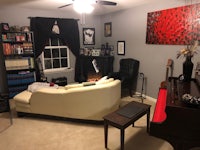 a living room with a piano and bookshelves