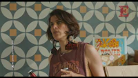a woman is standing in front of a wallpapered room