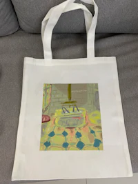 a white tote bag with a painting on it