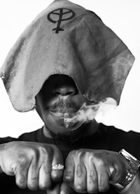 a black and white photo of a man smoking a cigarette
