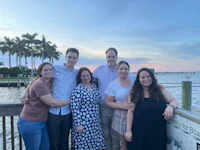 a group of people posing for a photo on a dock