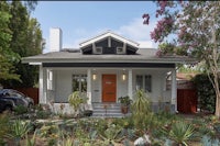a house with an orange door and a front porch
