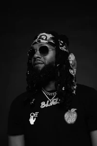 a black and white photo of a man with dreadlocks and sunglasses