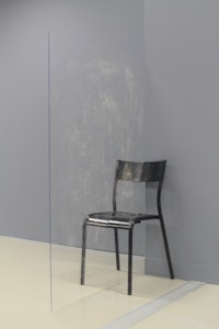 a chair sits in front of a glass wall