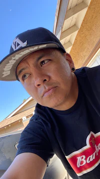 a man wearing a hat and taking a selfie