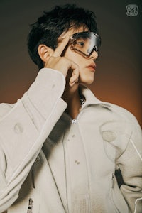 a young man wearing glasses and a jacket