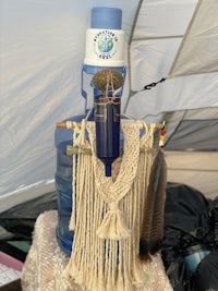 a blue water bottle with a feather hanging from it