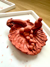 a red clay sculpture on a white tray