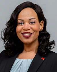 a black woman in a business suit smiling