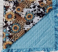 a baby blanket with a leopard print and sunflowers